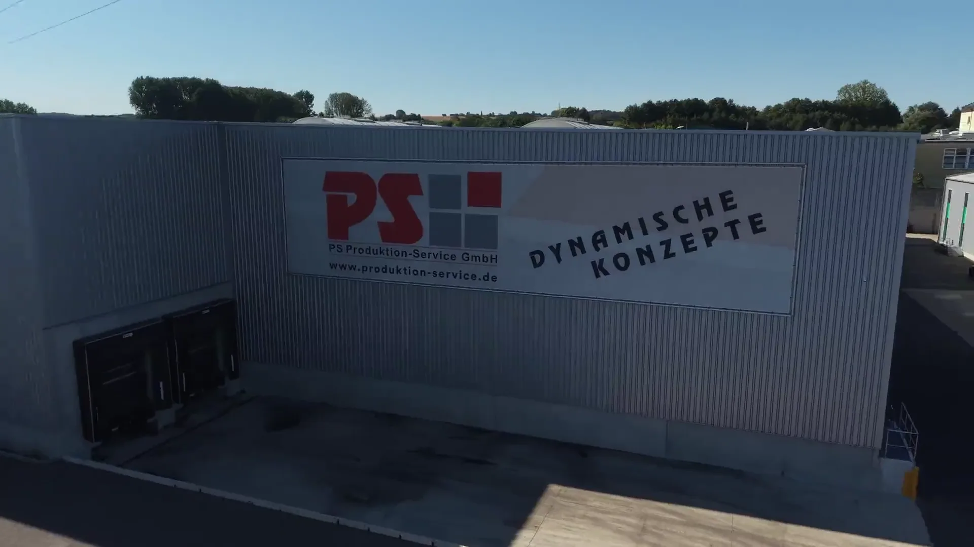Betriebsgelände der PS Produktion-Service GmbH mit Lagerhalle, Rampen und Firmenschriftzug