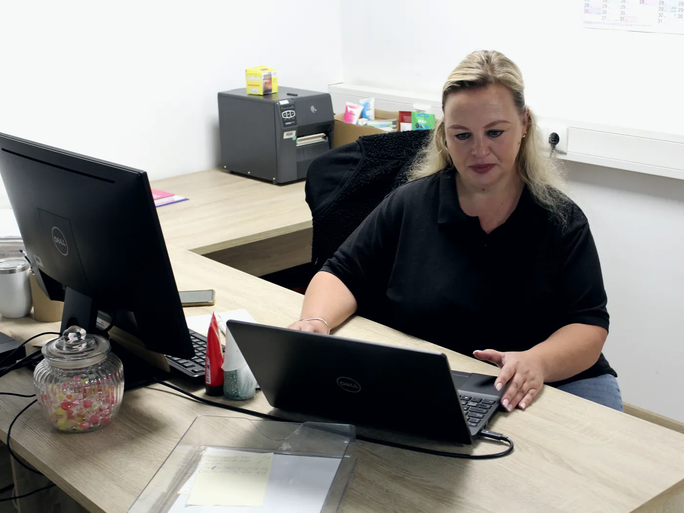 Mitarbeiterin bearbeitet Endkundenaufträge am Bildschirm im Büro