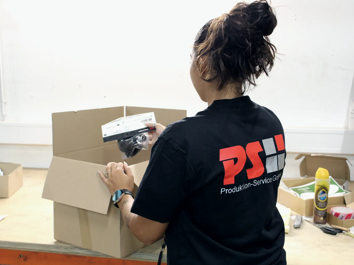 Mitarbeiterin bearbeitet eine Rücksendung am Packtisch
