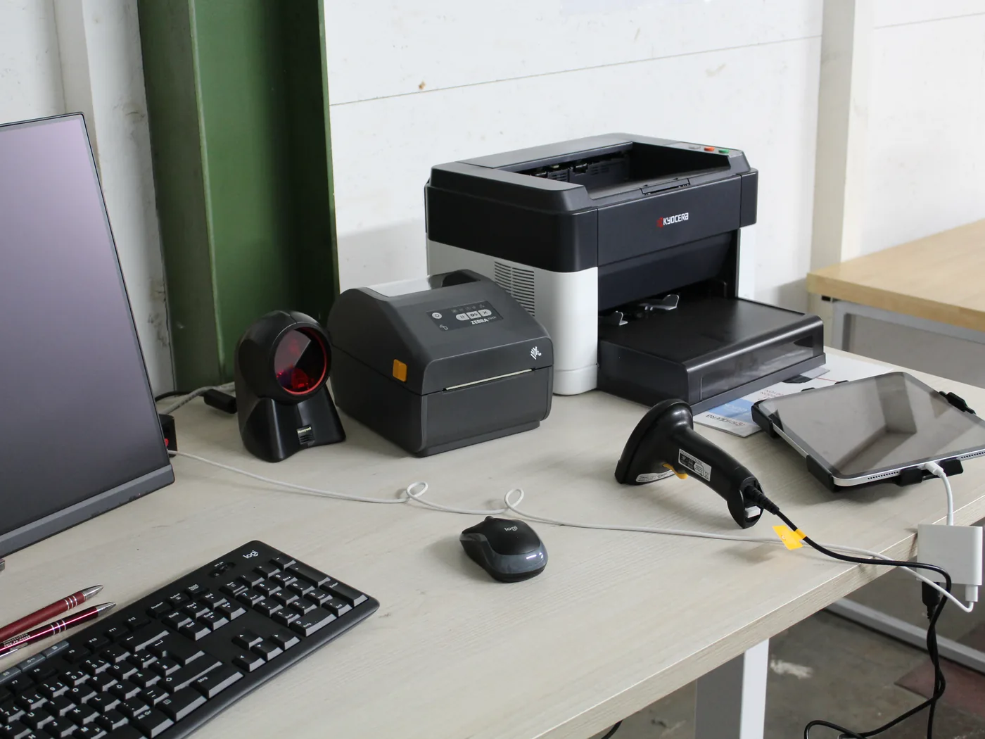 Warehouse workstation with screen, label printer, handheld scanner and tablet for recording stock movements